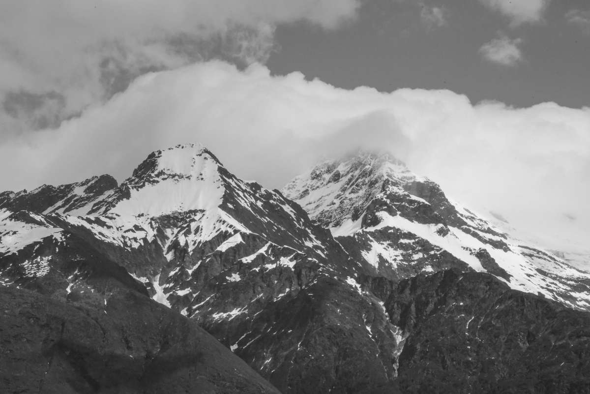 Snow on the peaks above the Matukituki Valley in winter with cloud rolling over