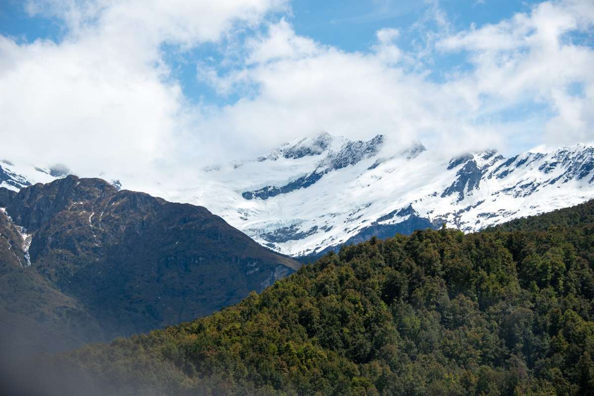 Snow-covered peaks of Mount Aspiring National Park above beech forest in winter